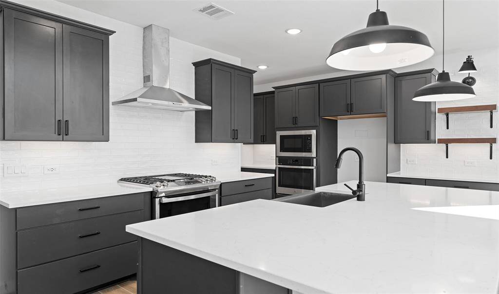Stylish kitchen with quartz countertops, grey cabinets, and floating shelves (*Photo not of actual home and used for illustration purposes only.)
