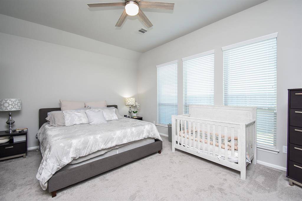 Primary bedroom with tall windows and lots of room.
