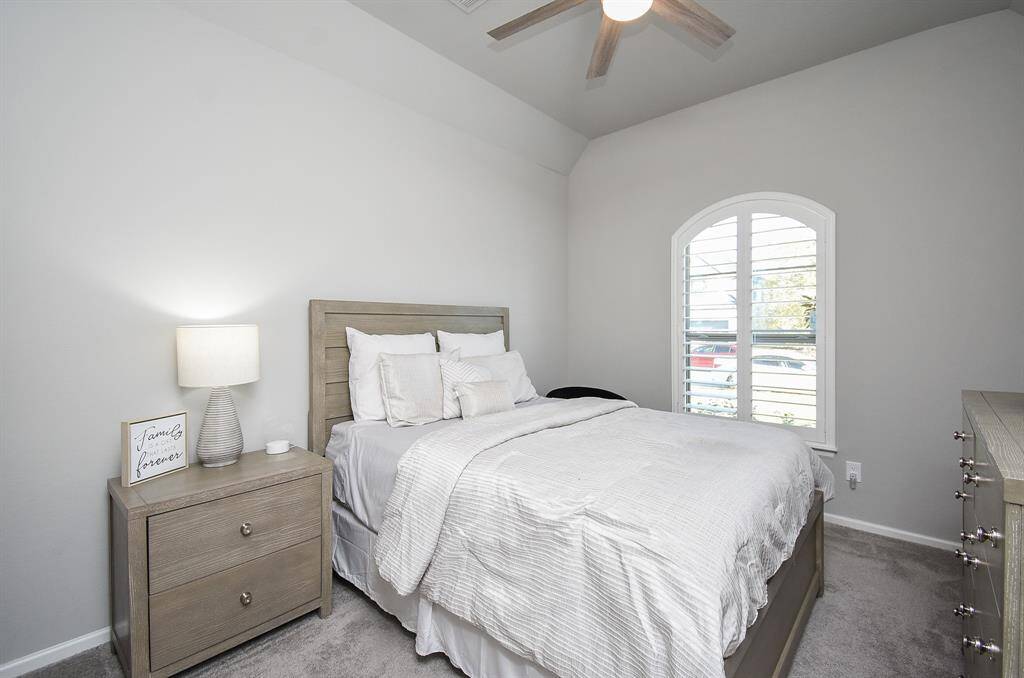 First guest bedroom is lovely with tall ceilings and custom shutters!