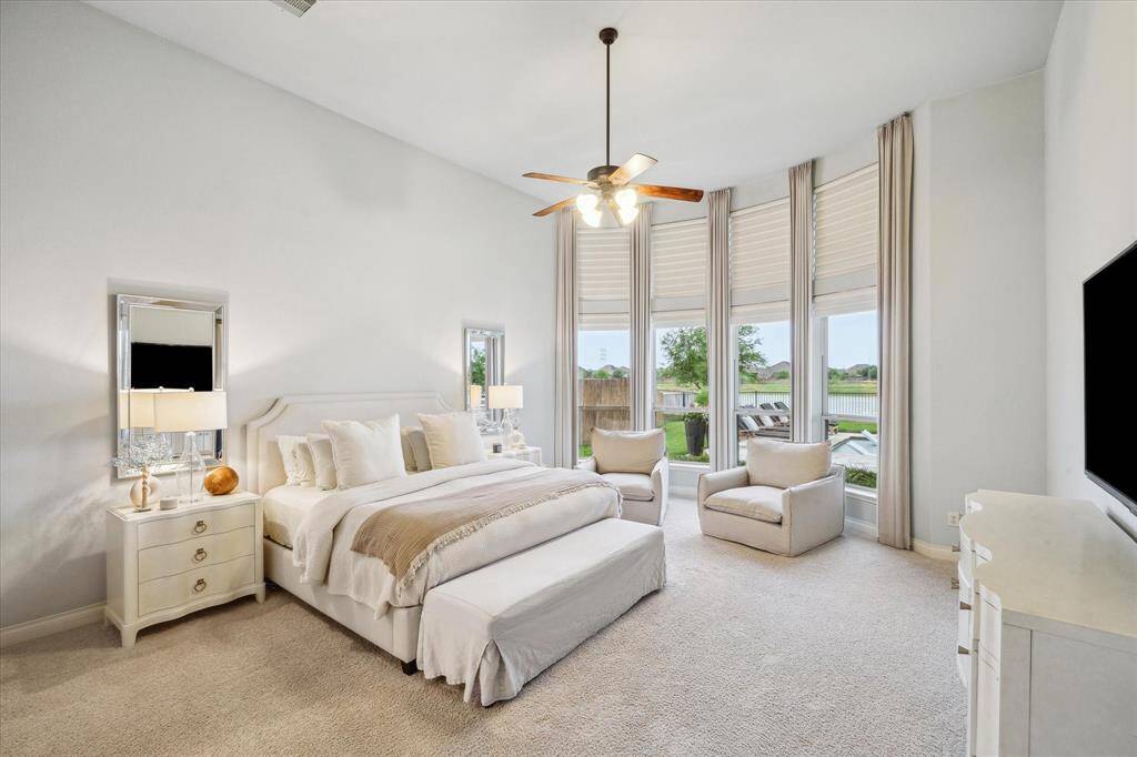 The primary bedroom with ceiling to floor windows with a perfect view of the water.
