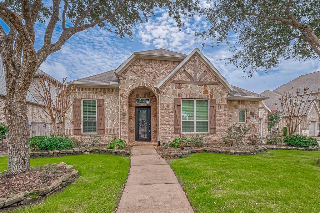 The well-maintained landscape and mature trees add warmth, while the long, welcoming sidewalk leads you to a charming covered front porch, inviting you home.
