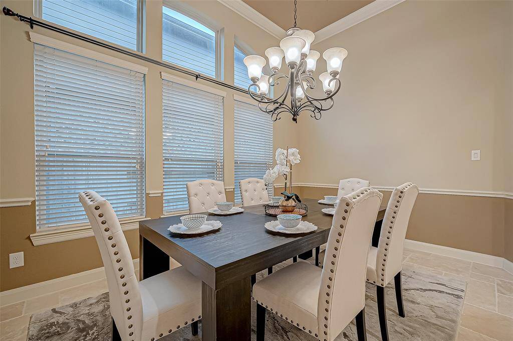 The dining room is beautifully framed by a stunning wall of large windows, filling the space with natural light and perfectly highlighting the impeccable finishes throughout.