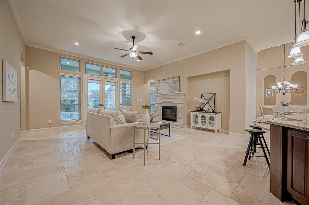 This home effortlessly flows along the elegant travertine flooring into a bright, open family room, perfectly positioned next to the stunning kitchen—creating a seamless and inviting living space.