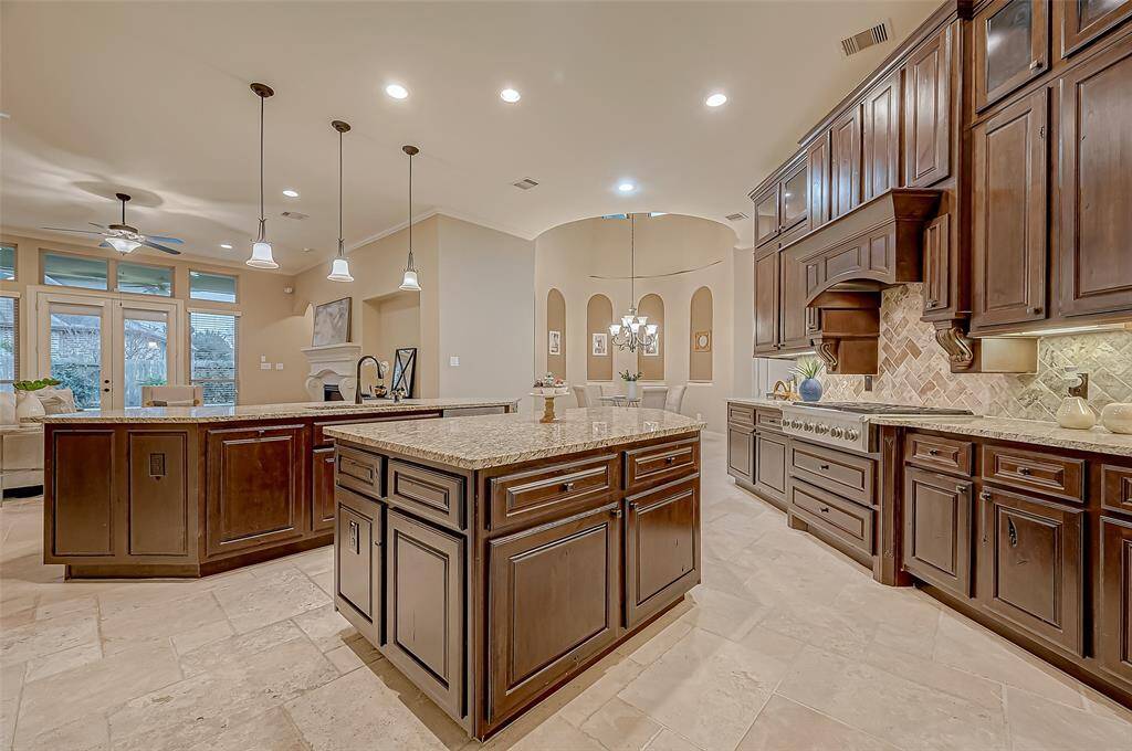 This kitchen is a true chef’s haven, featuring a 6-burner gas cooktop, a spacious island for prepping, and two convenient pull-out spice rack cabinets—designed for effortless cooking and entertaining!