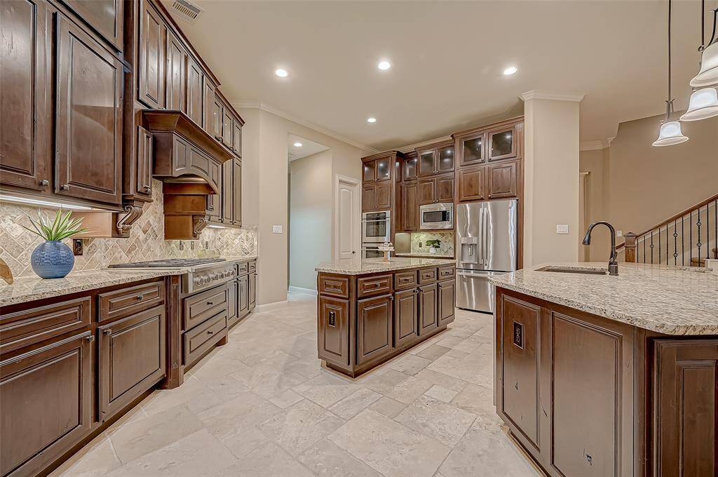 This kitchen features stainless steel appliances, including double ovens, a built-in microwave, and a spacious refrigerator nook—designed for both style and functionality!