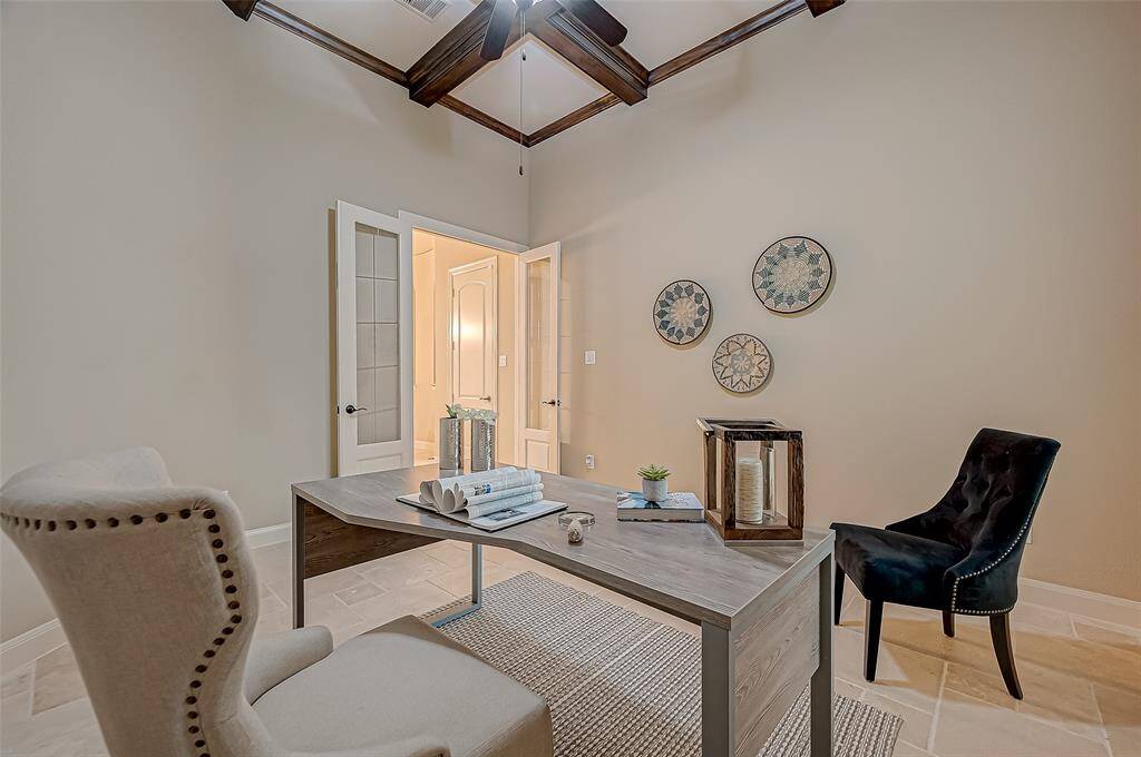 Tucked away for privacy, this stunning home office features rich stained wood ceiling beams and elegant French doors, offering a quiet retreat for work or creativity.