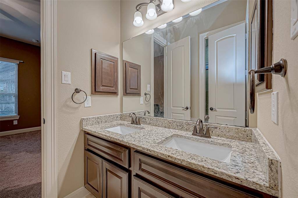 The Jack and Jill full bathroom between the second and third guest bedrooms features a stunning granite countertop, double sinks, and ample cabinet space, combining style and functionality for effortless daily living.
