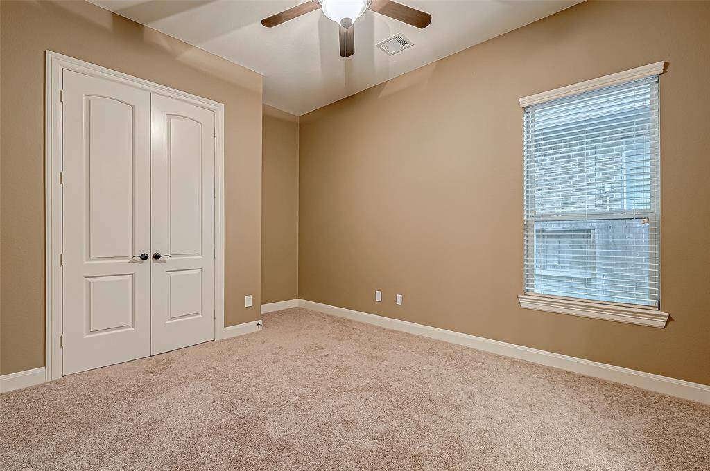 The third guest room offers a spacious closet for plenty of storage and a large window that fills the space with natural light, creating a warm and inviting atmosphere.