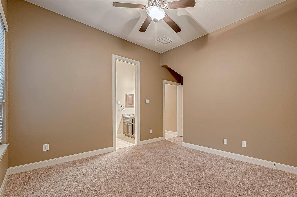 Here's another view of the third guest bedroom, featuring plush carpeting, a ceiling fan for added comfort, and convenient access to the Jack and Jill bathroom.