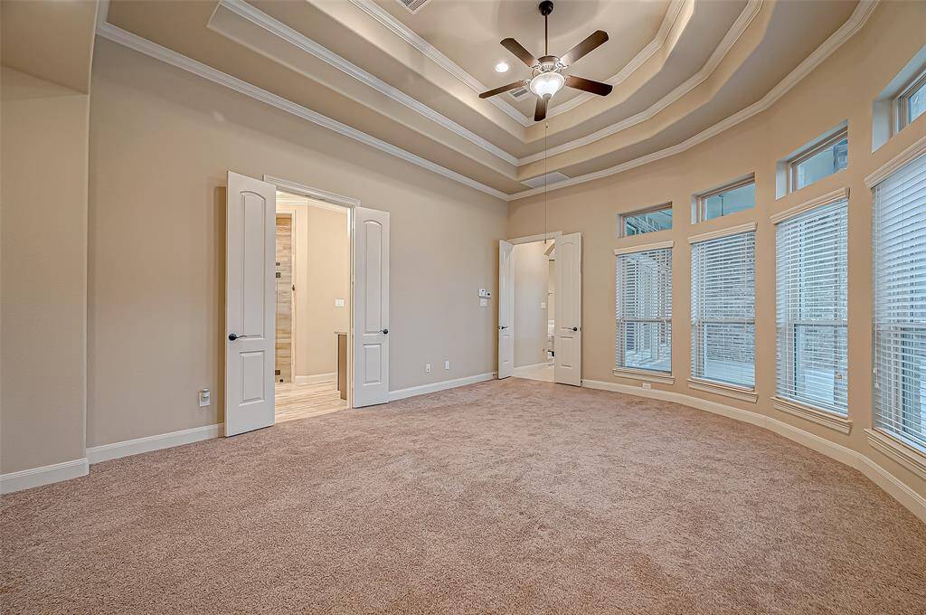 The primary bedroom offers a cozy retreat with plush carpeting, a ceiling fan for added comfort, and direct access to a spacious ensuite bathroom for ultimate relaxation.