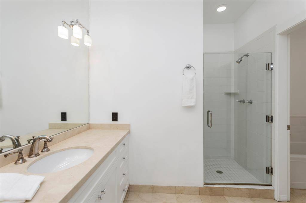 Primary bathroom includes custom cabinetry, separate bath tub and separate standing shower.