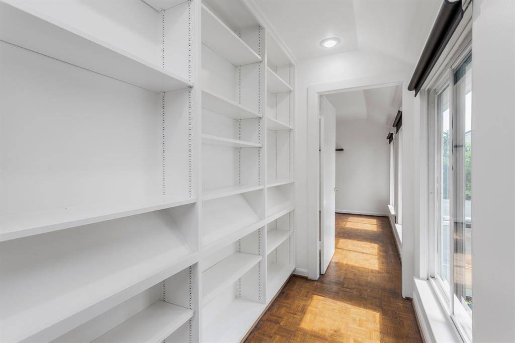 Hallway leading to the 2nd bedroom with large windows providing natural light.