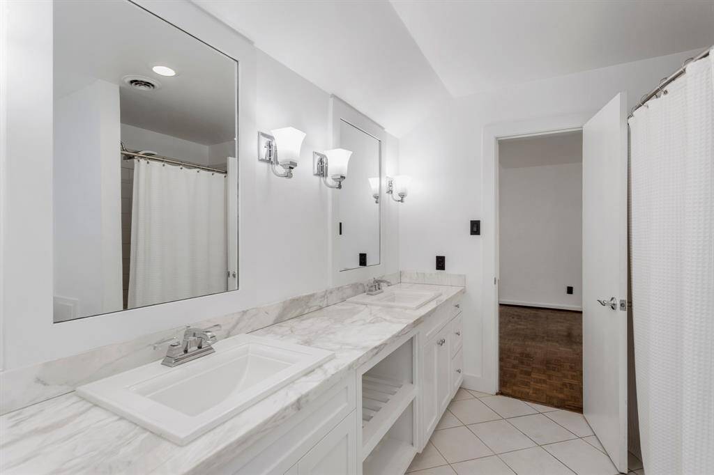 Ensuite bathroom on second floor perfectly placed in between the great room and secondary bedroom. Bathroom includes his and her sinks, beautiful white custom cabinetry and stand alone shower.