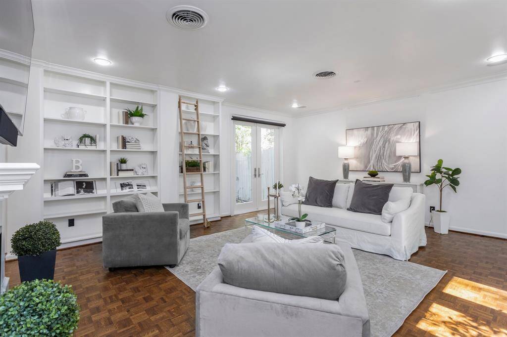 Entry way leads straight into the formal living area with beautiful shelving and fire place. Notice the beautiful wood flooring.