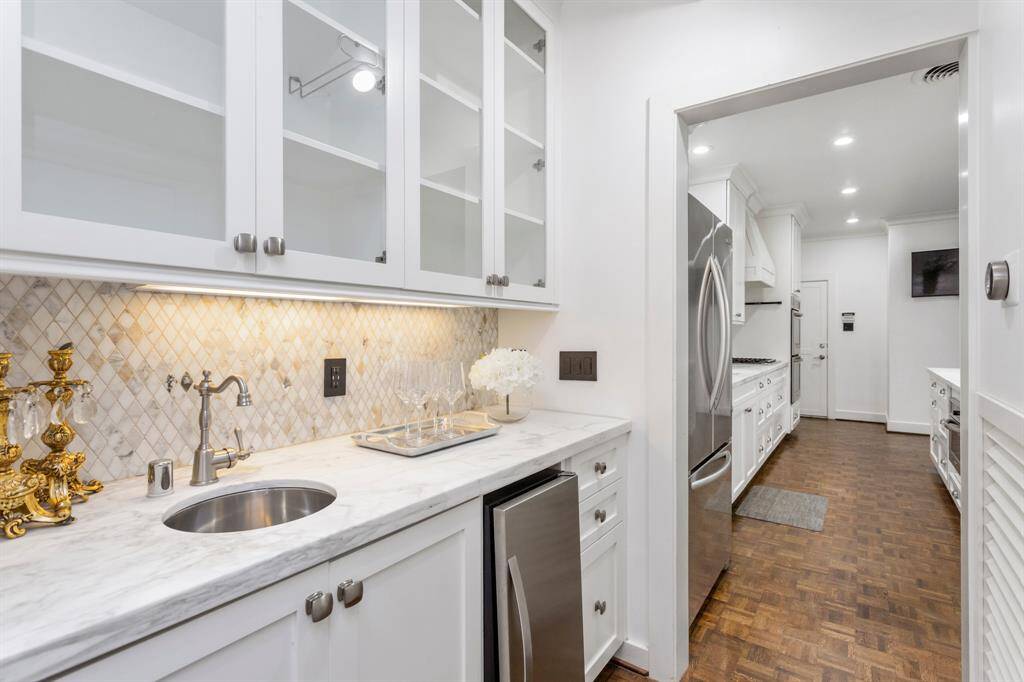 Butler's pantry found in between the living room and kitchen featuring great cabinet space, sink, and ice maker.