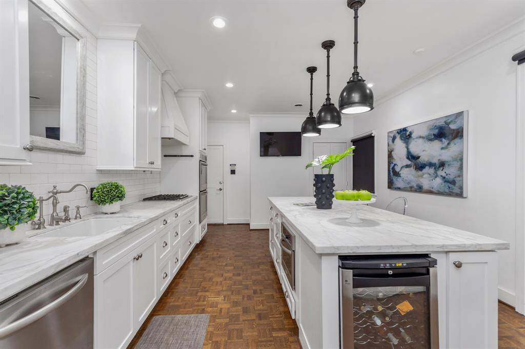 This beautiful kitchen is great for entertaining and hosting. The kitchen features a huge island, wine refrigerator, double oven, huge farmhouse sink, and great natural lighting.