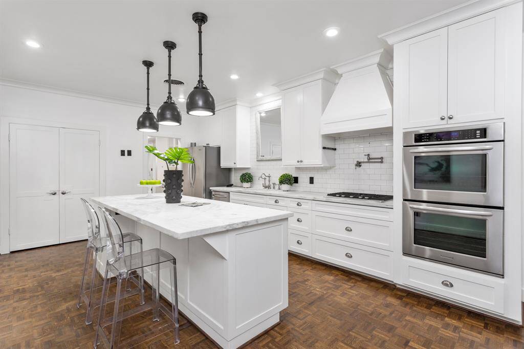 Additional view of the kitchen. This beautiful kitchen is great for entertaining and hosting. The kitchen features a huge island, wine refrigerator, double oven, huge farmhouse sink, and great natural lighting.
