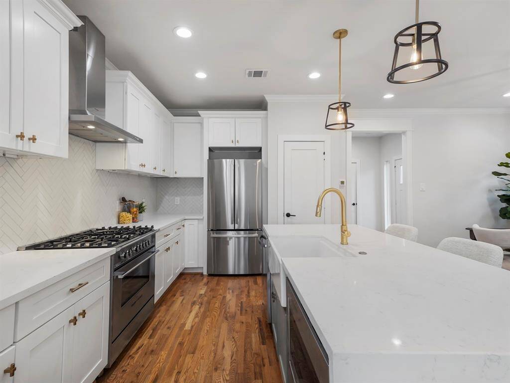 Modern and elegant kitchen featuring a stunning quartz waterfall island that serves as a stylish focal point. Sleek stainless steel appliances complement the contemporary design, while ample cabinetry provides both functionality and storage. The open layout and high-end finishes make this kitchen perfect for cooking and entertaining.