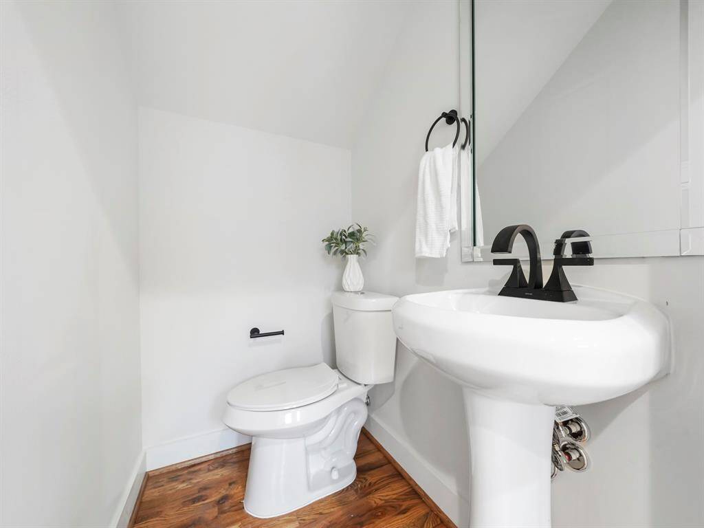 Charming half bath featuring modern fixtures and a sleek design. The stylish vanity, clean lines, and contemporary finishes create a functional and elegant space for guests. The well-lit room adds a touch of convenience and sophistication to the home’s layout.