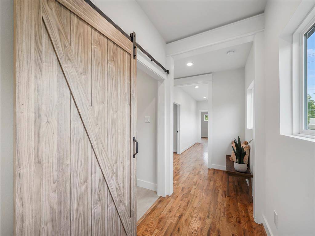 Functional utility room with a stylish barn door, adding a touch of rustic charm to the space. The room is designed for convenience, offering ample storage and organization for laundry essentials, while the barn door enhances the room's aesthetic and provides a sleek, space-saving solution.