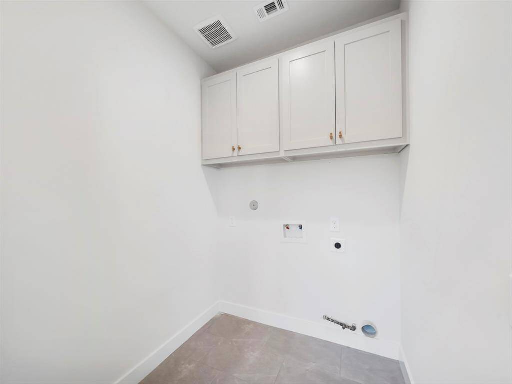 Functional utility room with a stylish barn door, adding a touch of rustic charm to the space. The room is designed for convenience, offering ample storage and organization for laundry essentials, while the barn door enhances the room's aesthetic and provides a sleek, space-saving solution.