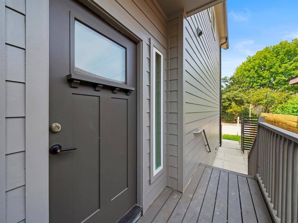 Elegant black front door with sleek glass paneling, with large window that enhances natural light and curb appeal. The covered porch offers a welcoming entryway. A gated front entry adds privacy and security, completing the perfect blend of modern and Craftsman charm.