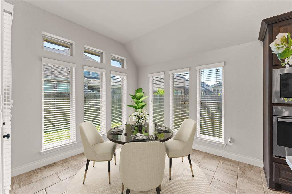 The breakfast area is filled with light, thanks to wide windows that frame views of the backyard.