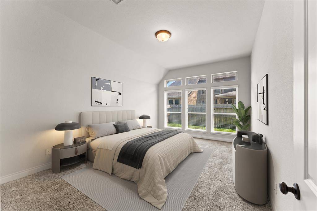 The primary bedroom is a spacious retreat with plush carpet flooring for comfort underfoot. Wide windows bring in soft light, creating a calm and restful atmosphere.