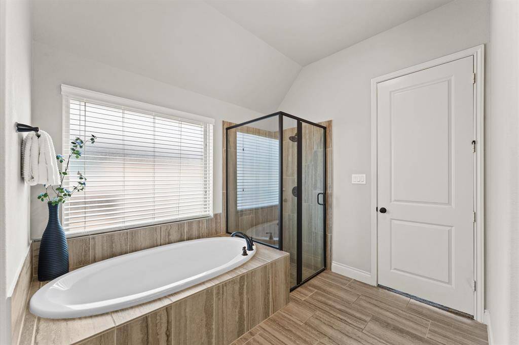 The en suite bathroom features a luxurious garden tub, perfect for unwinding in peace and a separate walk-in shower that offers a refreshing start to your day.