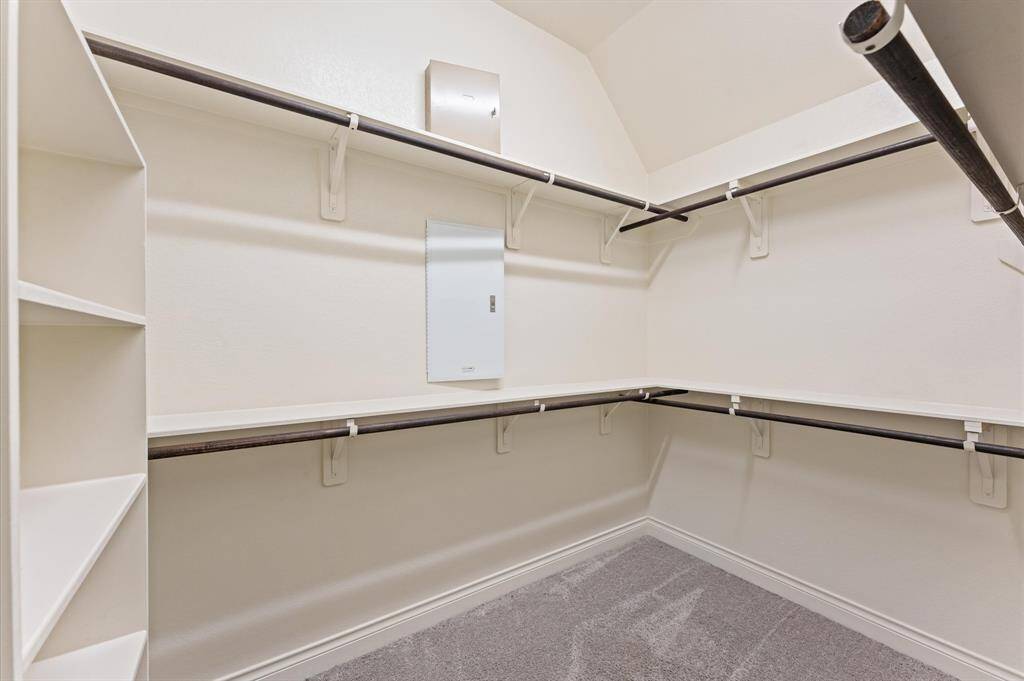 The spacious walk-in closet offers ample room for organizing clothes, shoes, and accessories. Hanging rods and built-in shelving make it easy to keep everything in its place.