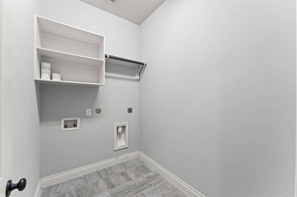 The laundry area is conveniently located for daily use. Simple and efficient, it helps the flow of everyday life.