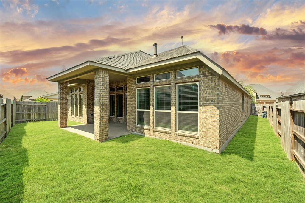 The backyard has a lush green lawn with room to relax or play. It’s a peaceful space to enjoy the fresh air and quiet moments.