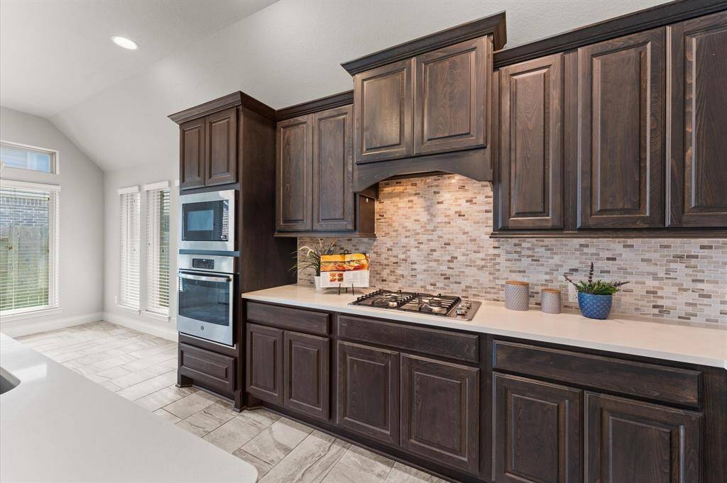A beautiful tile backsplash adn under cabinet lighting ties the design together with elegance.