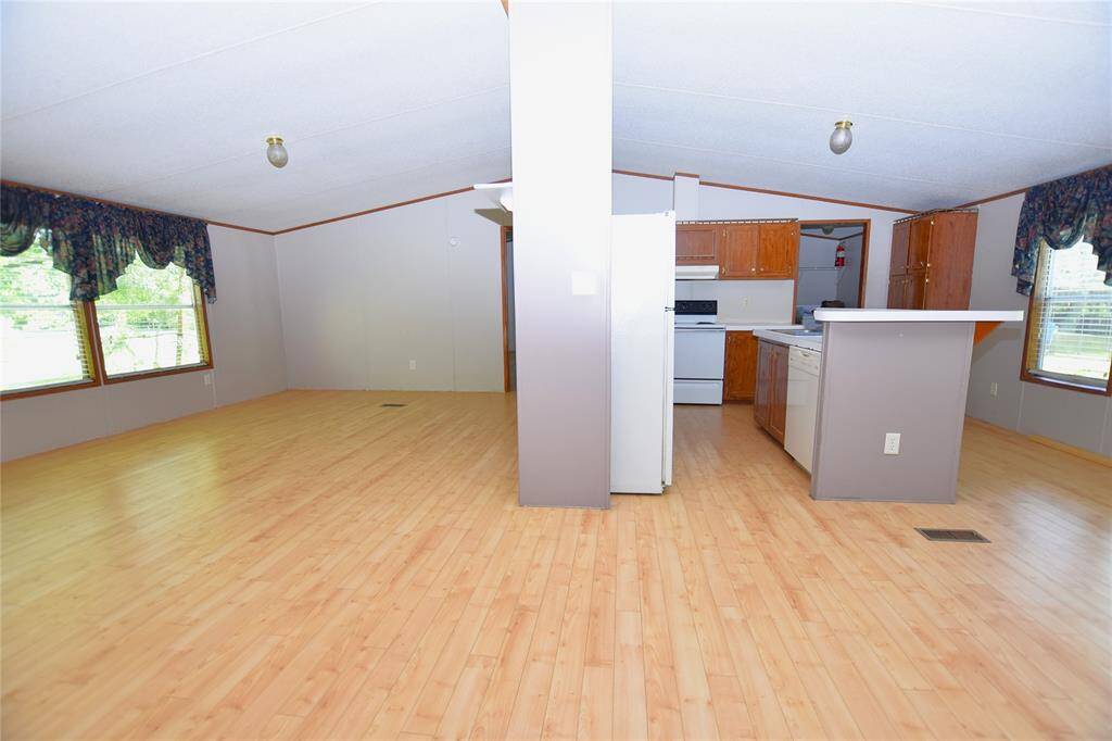 This inviting living room offers a spacious, open layout that seamlessly flows into the adjacent dining room, creating a perfect space for both everyday living and entertaining.