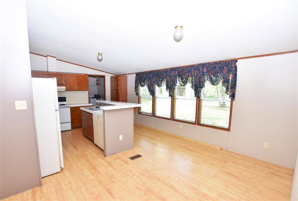 Whether preparing meals or enjoying a quiet moment, this setup offers a balance of openness and separation, allowing the living and dining areas to remain the heart of the home while maintaining a distinct space for cooking and meal prep.