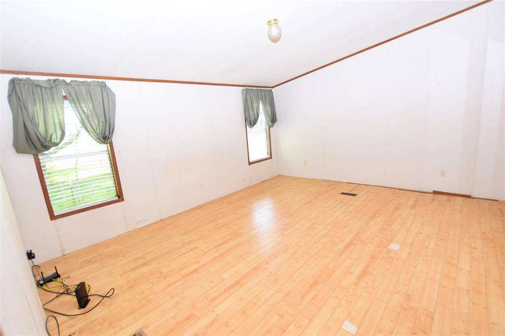 This serene primary bedroom offers a peaceful retreat, featuring two large windows that flood the room with natural light, creating a warm and inviting atmosphere.