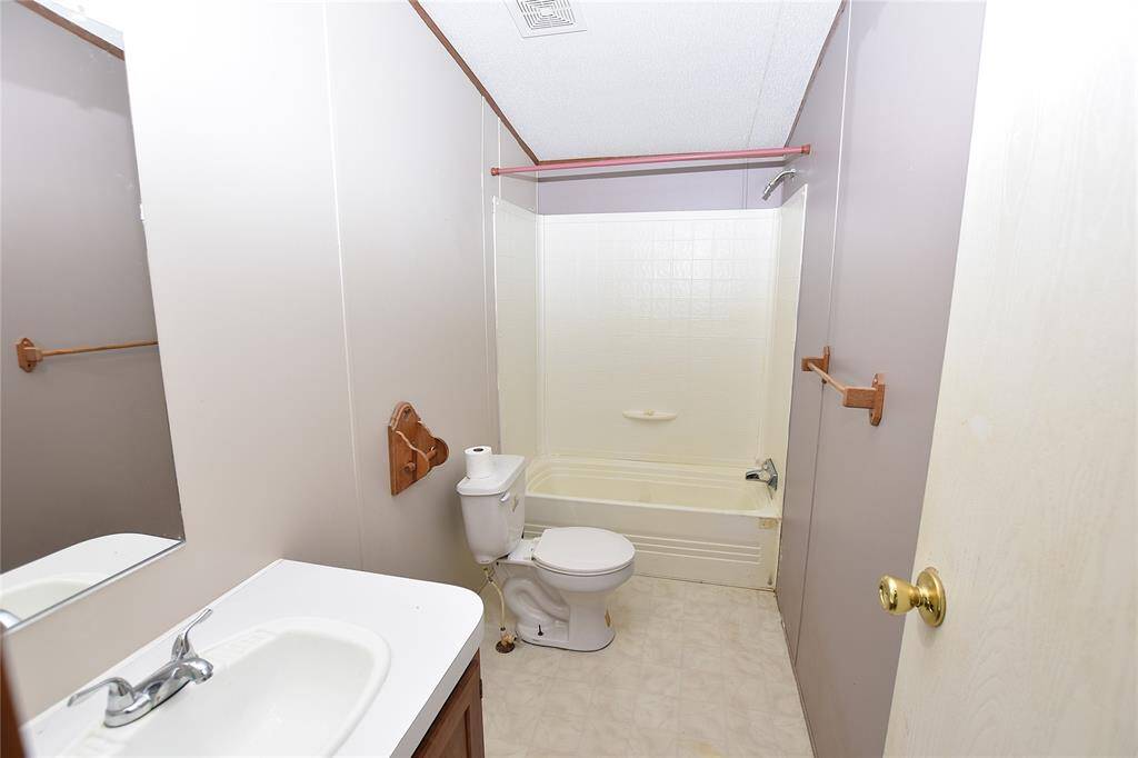 This well-appointed secondary bathroom offers both practicality and comfort.
