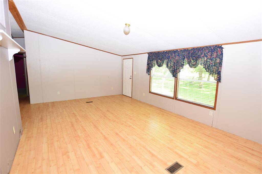 As you enter the home, you're immediately greeted by a spacious and inviting living room, highlighted by a large window that fills the space with natural light.