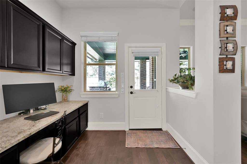 This versatile extra desk space offers a convenient and stylish home office setup, featuring more cabinetry for extra storage and a granite countertop workspace. Positioned near the back door, it provides easy access to the outdoors, making it ideal for transitioning between work and relaxation.