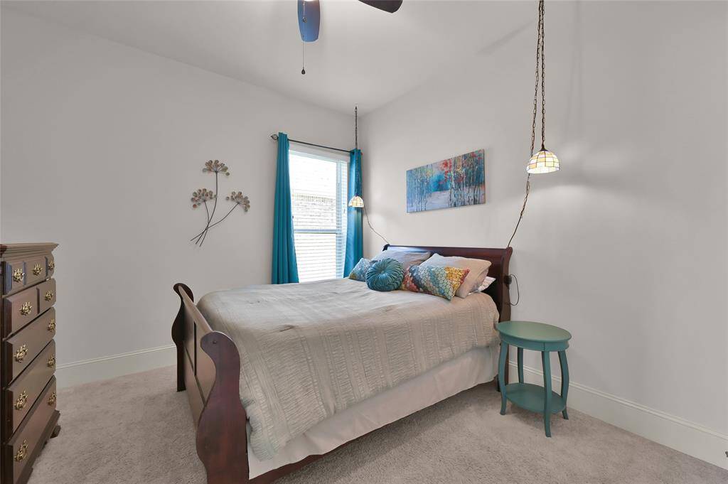 This cozy secondary bedroom has a bright window with carpet creating a welcoming atmosphere.