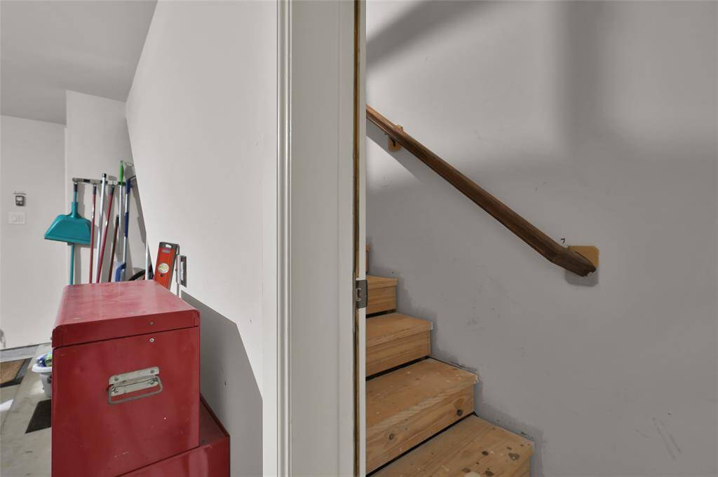 Look for this wooden staircase in the garage leading up to a Texas basement with plenty of functional space for storage and maintenance.