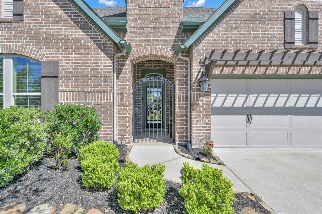 Gated archway entrance to front porch for extra security. This home has great curb appeal in a peaceful neighborhood setting within walking distance of trails woven throughout the community.