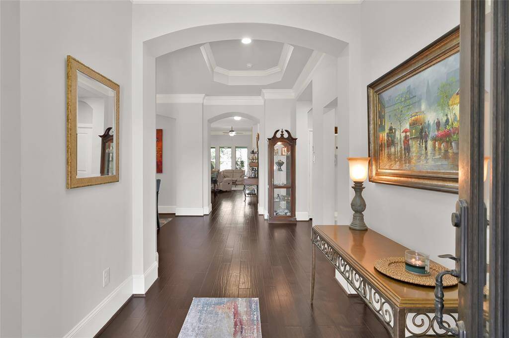 A welcoming first impression for family and guest, this elegant entryway features dark hardwood floors, a decorative ceiling with archways and leads to a bright, open living spaces.