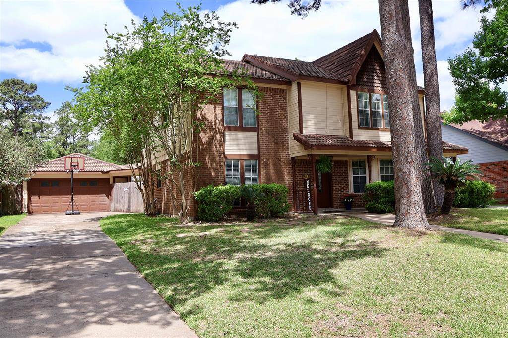 This beautiful two-story home features a classic brick exterior. It includes a spacious two-car detached garage and a well-maintained front yard with lush greenery, offering great curb appeal.