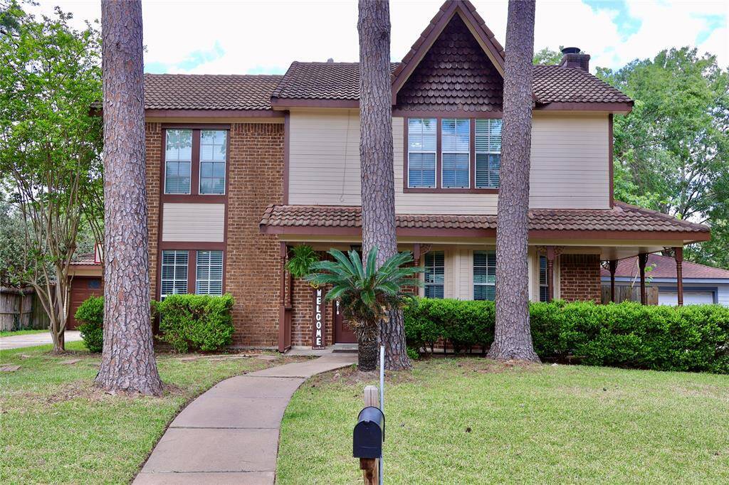 This beautiful two-story home features a classic brick exterior. It includes a spacious two-car detached garage and a well-maintained front yard with lush greenery, offering great curb appeal.