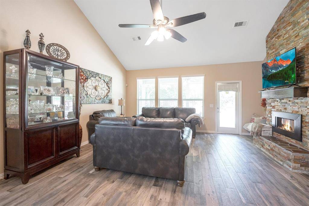 The family room is the perfect place to relax and unwind or catch up with family and friends. With wood-look tile flooring, neutral paint, a soaring ceiling, and a sleek electric fireplace set in a stunning stone surround, this space combines comfort and style in all the right ways. You’re going to love calling this home.