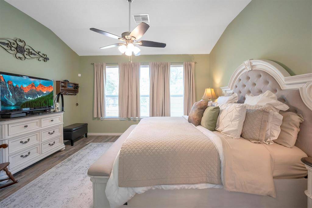 This spacious suite has plenty of room for your California King bed and other large furnishings, with wood-look tile flooring, neutral paint, and a wall of windows bringing in soft natural light. Tucked behind a modern sliding barn door, the luxe ensuite completes this peaceful retreat—the perfect place to begin and end your day.