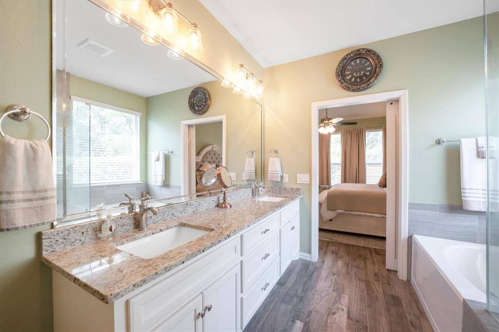 This expansive vanity provides plenty of elbow room for morning routines, while gorgeous granite countertops, under-mount sinks, a beveled mirror, and stylish vanity lights add a touch of luxury to your daily rituals.