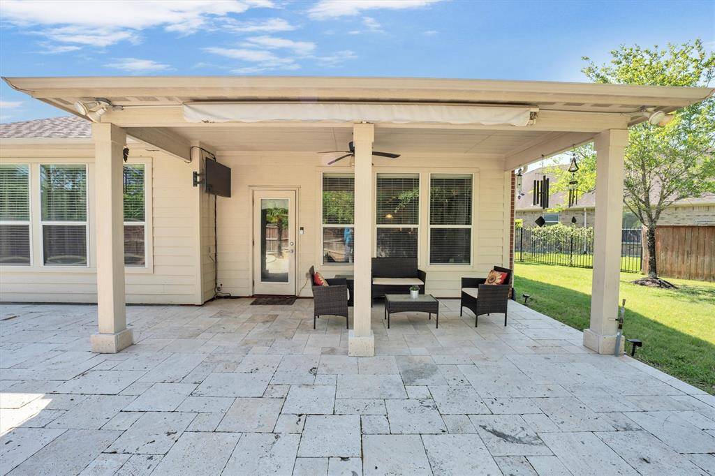 The spacious covered patio sets the stage for year-round entertaining, with plenty of room to dine, lounge, and enjoy the outdoors—rain or shine. Whether you're hosting a summer pool party or a cozy fall gathering by the firepit, this backyard is ready for it all.