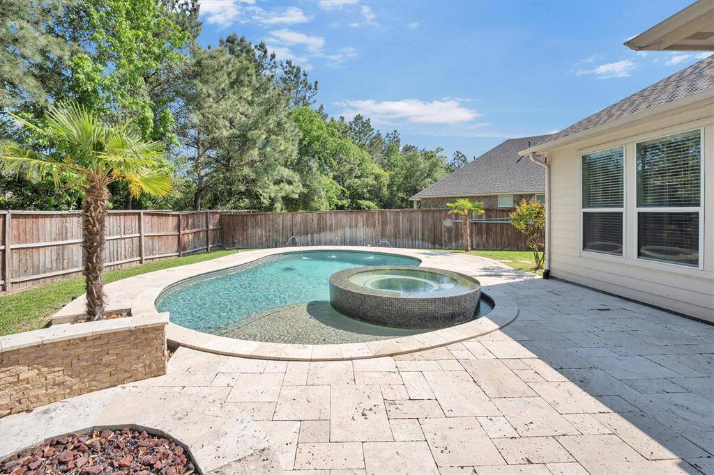 Beat the heat or soak your cares away in this resort-style backyard featuring a sparkling pool with a tanning ledge and a raised spa with convenient remote control. Surrounded by lush greenery and privacy fencing, it's the ultimate spot to relax, recharge, and entertain in style.